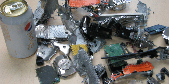 Photograph of a can of Diet Pepsi next to a pile of destroyed hard drives.